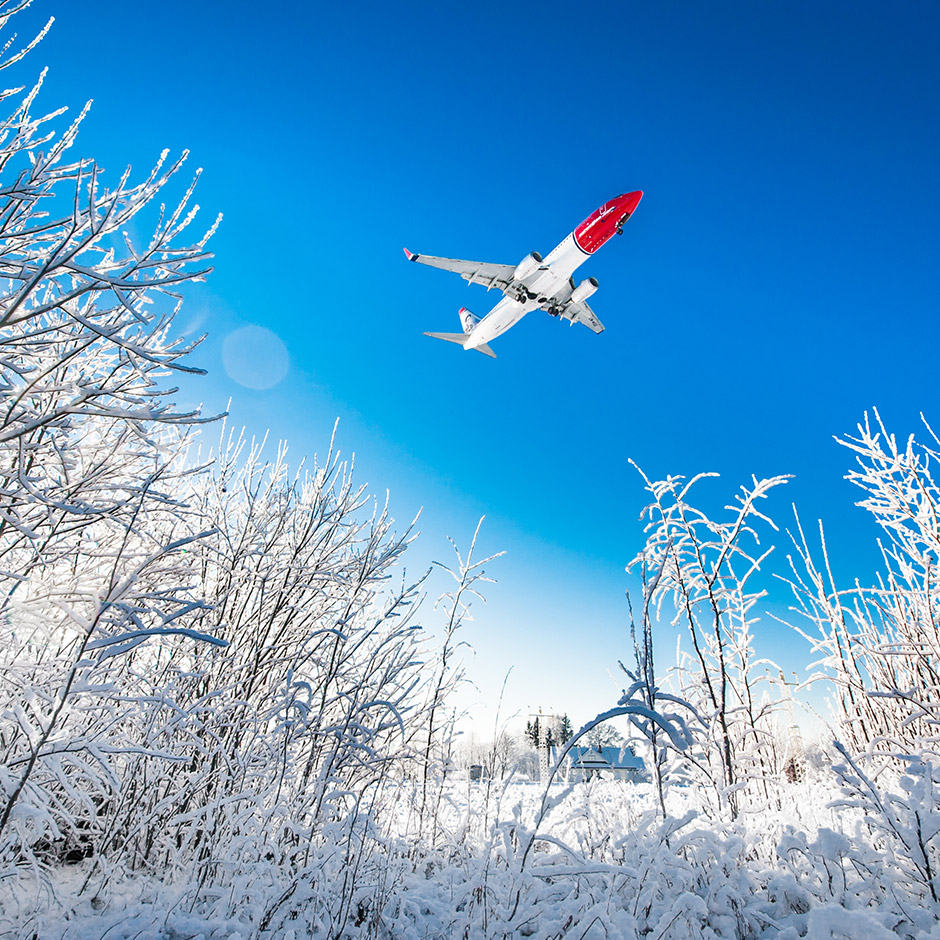 Norwegian fly flyver over sneklædt landskab